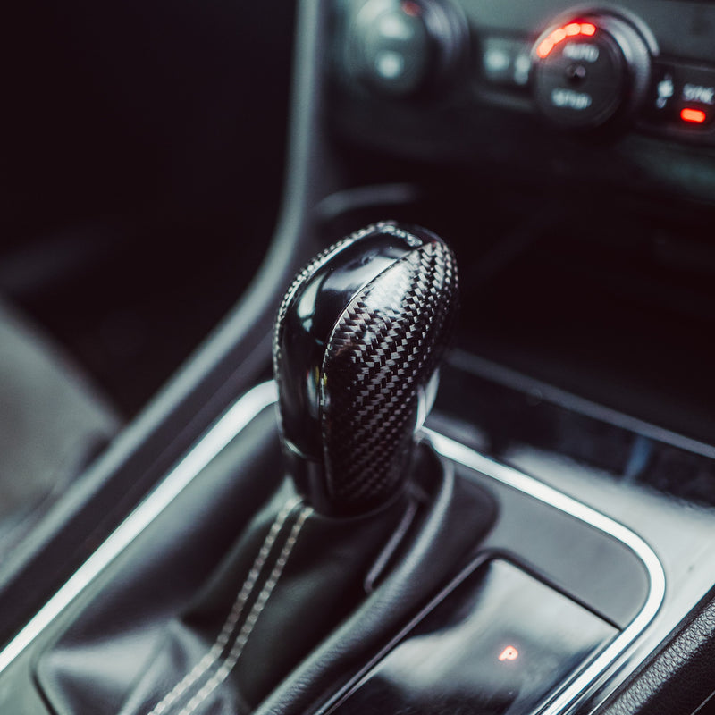 Close-up of a car's gear shift lever and control panel.