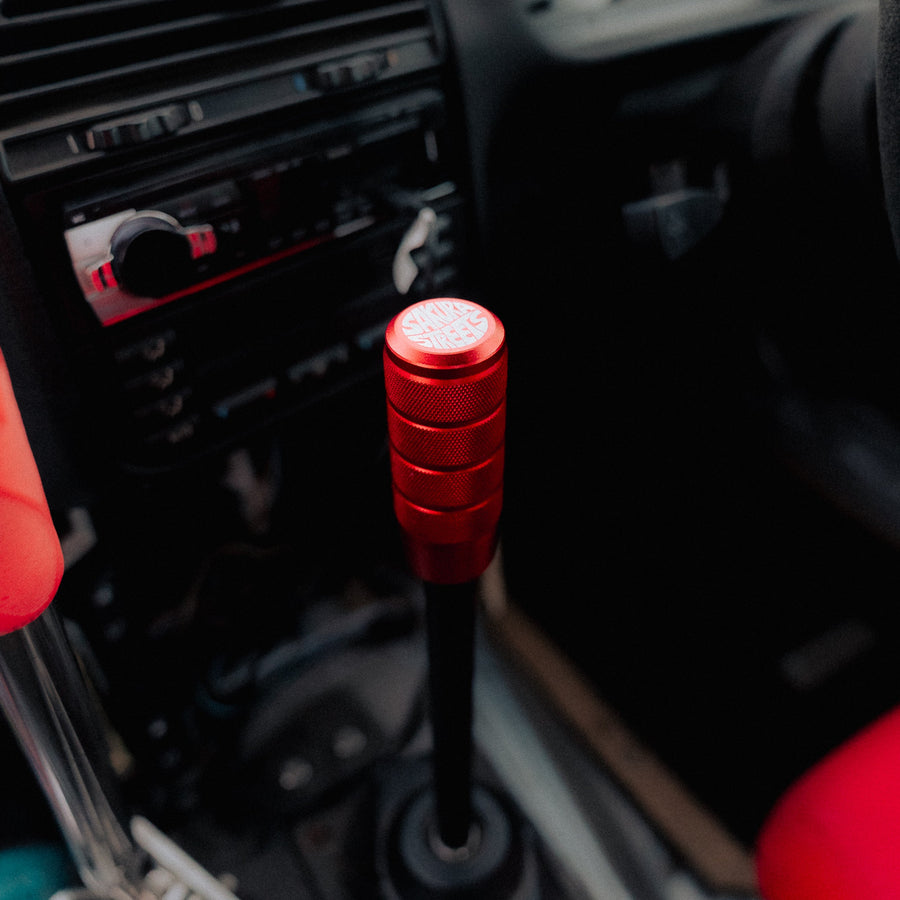 Red car gear shift lever in a vehicle interior