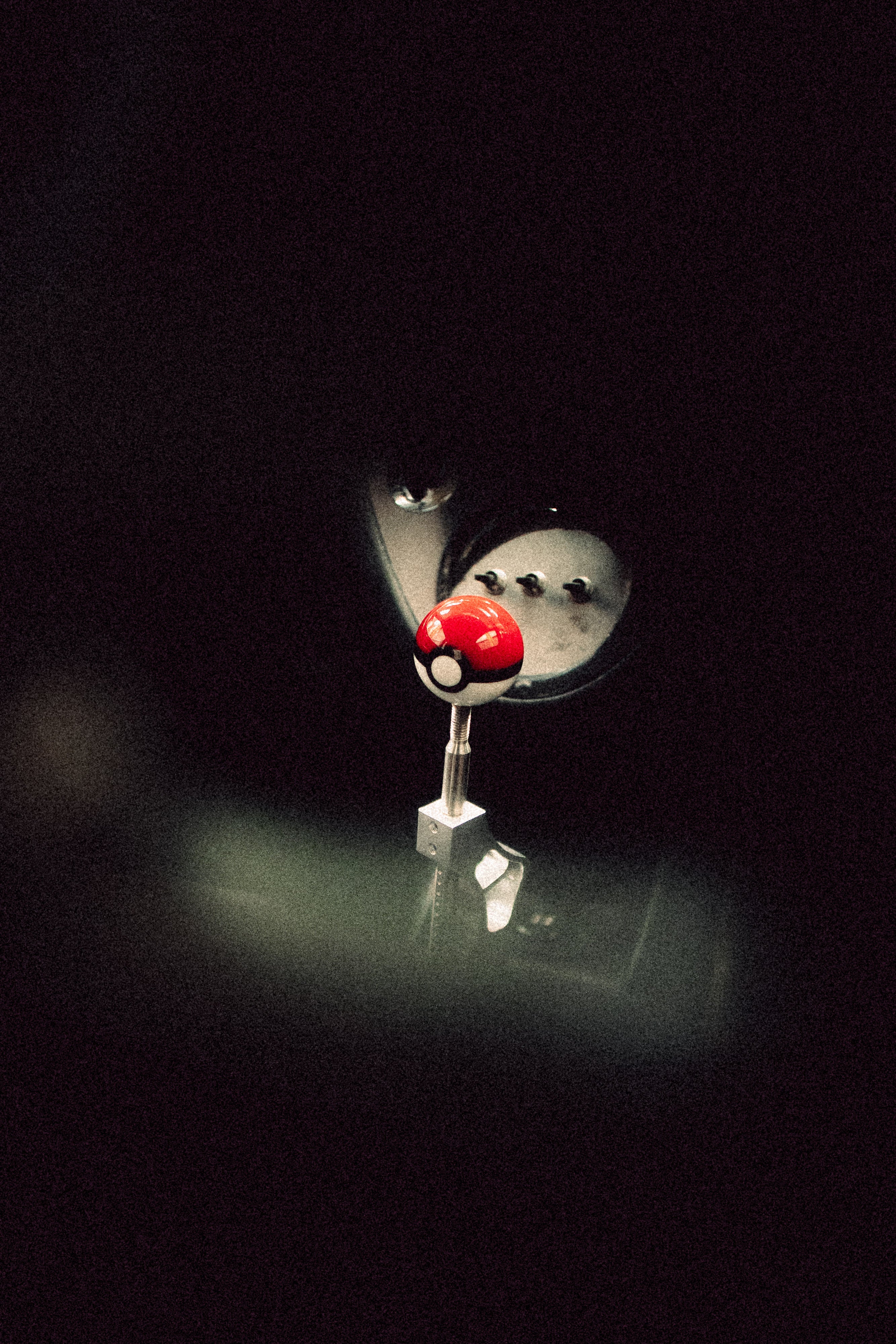 Close-up of a Poké Ball shift knob fitted to a honda