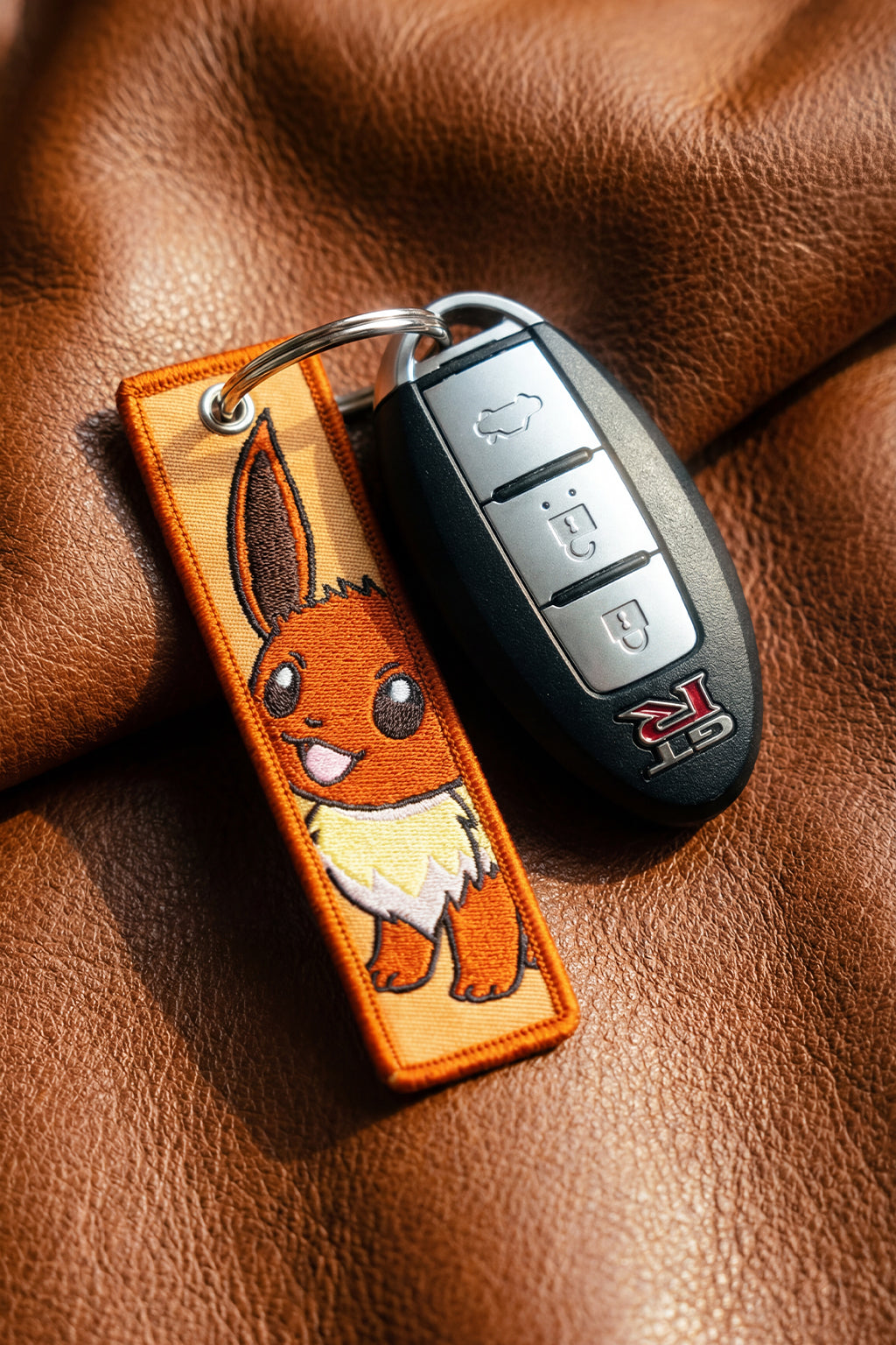 Eve Flight tag sat on some luxury leather while attacthed to a Nissan GTR R35 key