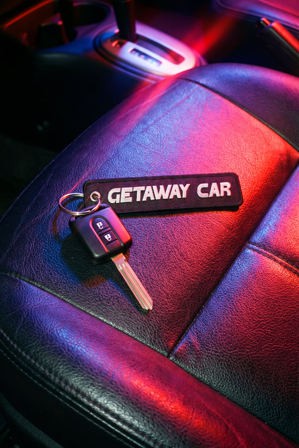 Key with 'Getaway Car' keychain on a car seat