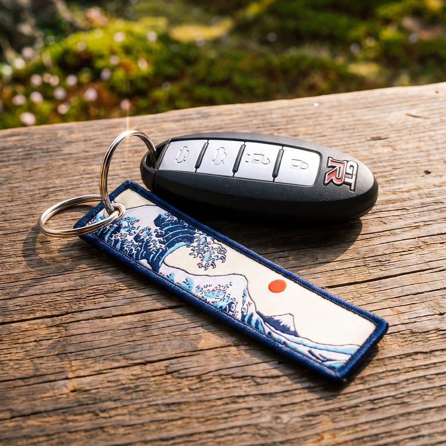 Key fob and decorative keychain on a wooden surface with a blurred natural background