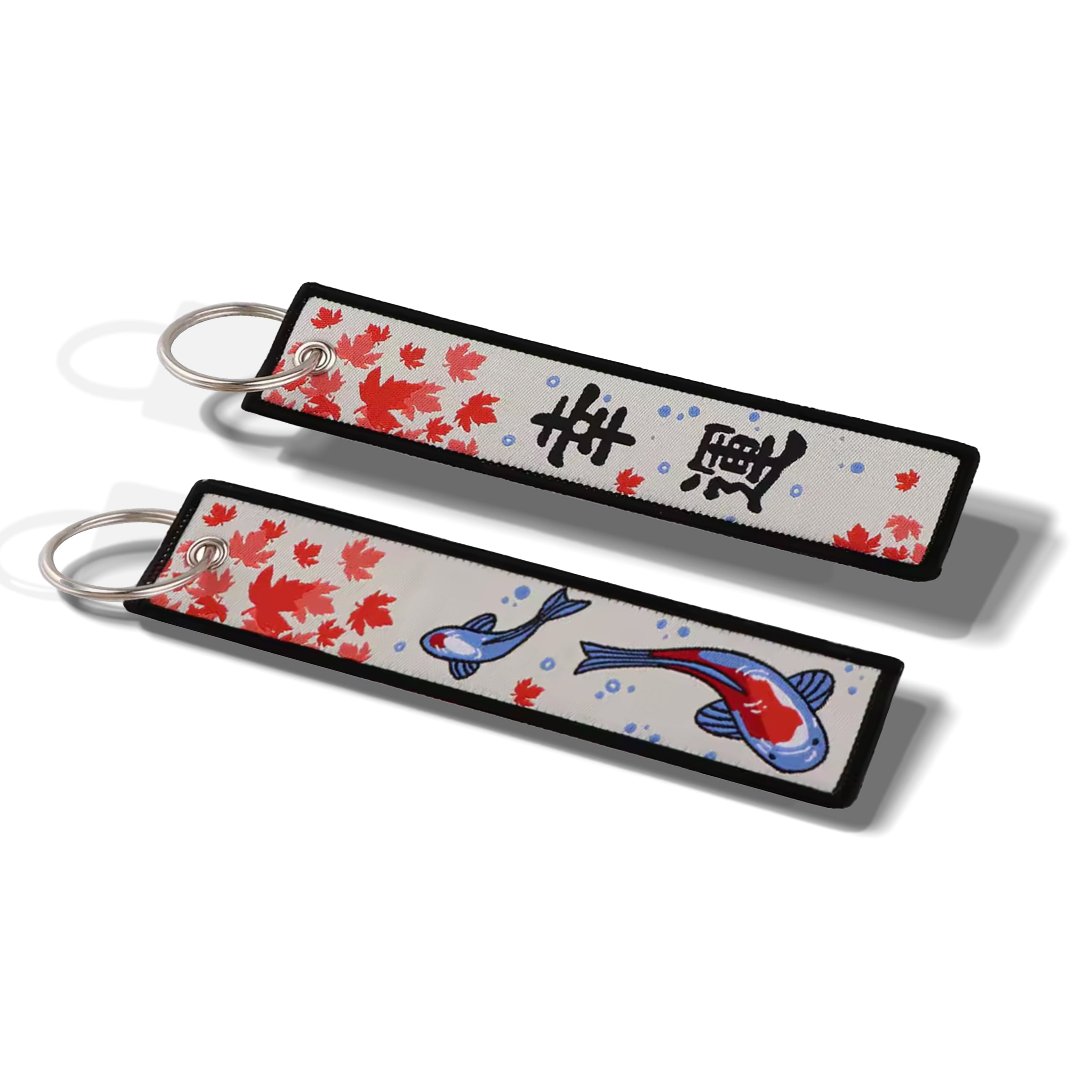 Two rectangular keychains with silver split rings, featuring a white background decorated with red floral patterns, black kanji characters, and blue and red koi fish, shown on a white background.