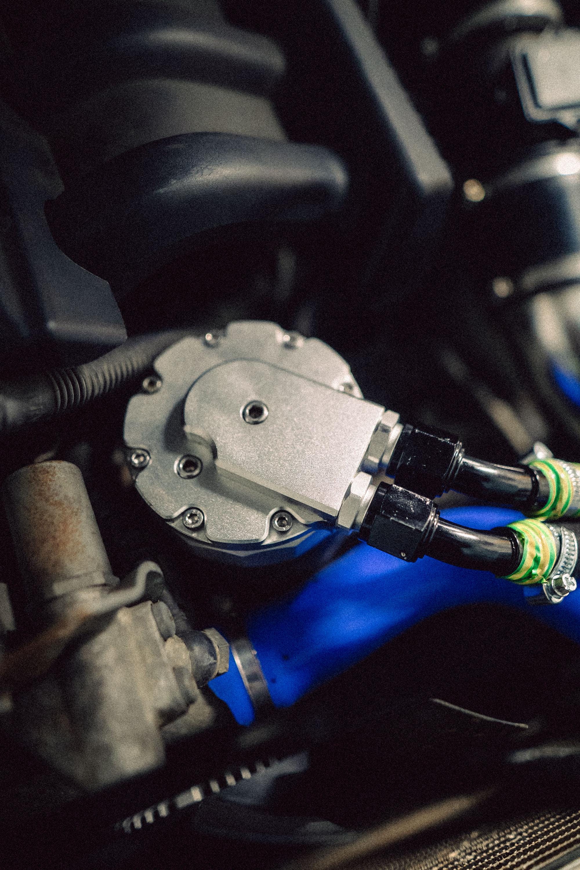 Close-up of a mechanical component with hoses and connectors on a dark background