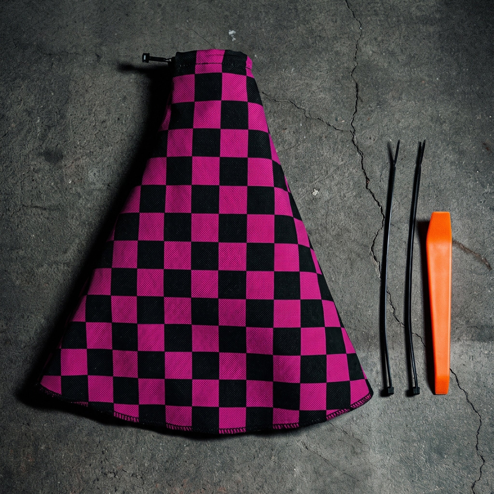 Car gear shift with a pink and black checkered cover inside a vehicle.