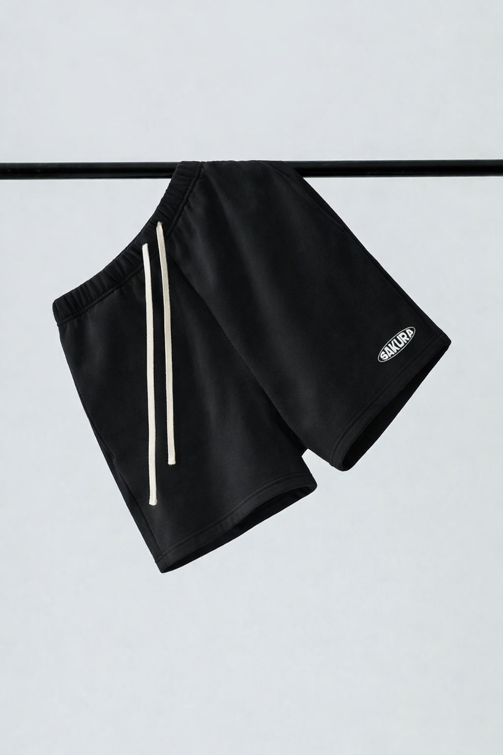 Black shorts with white stripes on a light gray background